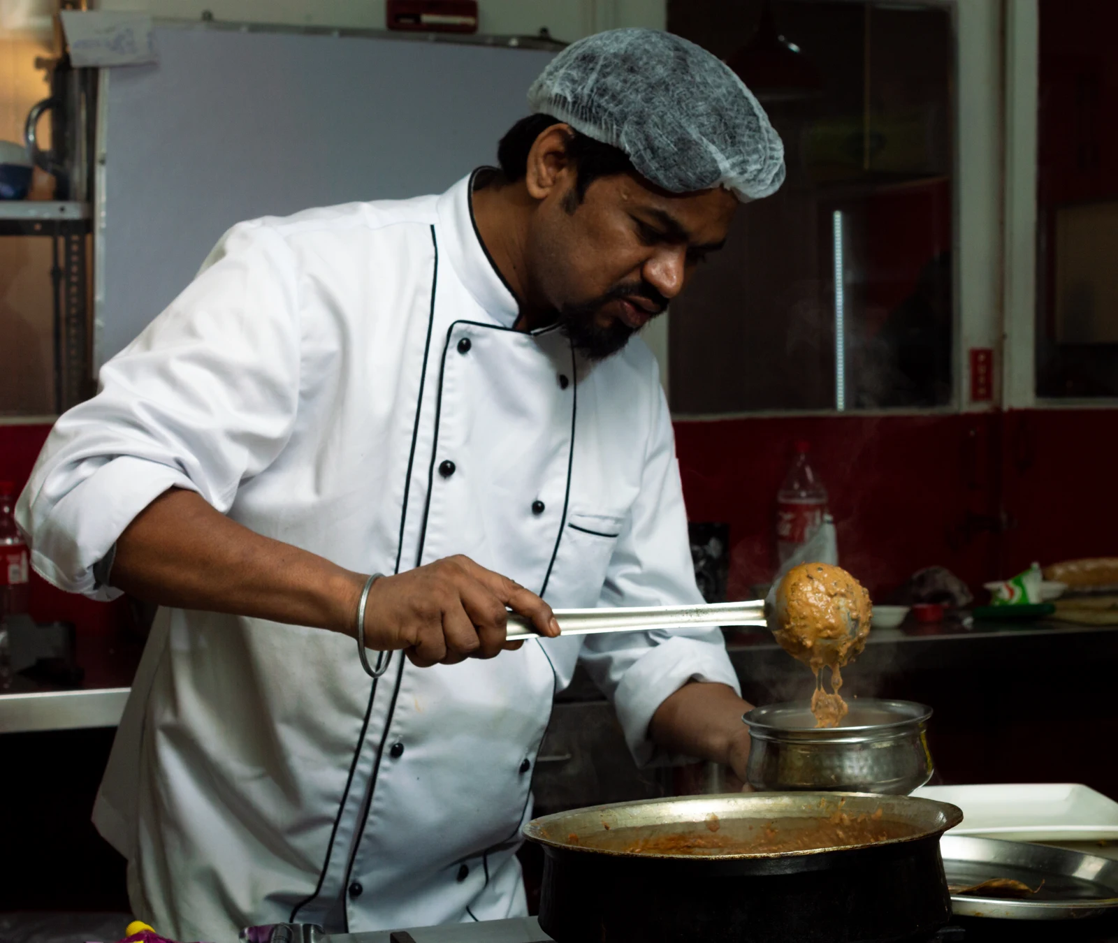 Academy cooking preparation — original archive photograph Cook in a white uniform preparing food with a ladle beside a pan